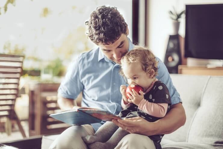 Niña leyendo fábulas cortas con su papá