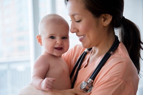 Bebé sonriendo con la doctora.