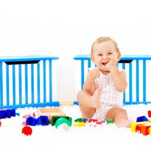 Es importante saber a los cuántos meses se sienta un bebé y acompañar este proceso Bebé sonriendo sentado al lado de sus juguetes