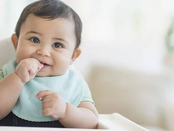 Bebé de 9 meses sentado sonriendo