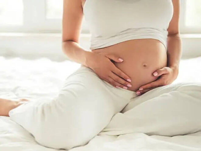 Conoce qué es el líquido amniótico y su función. Mamá tocando el vientre.