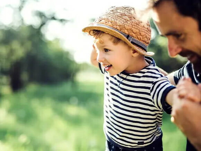 Conoce qué es la motricidad gruesa y cuáles son sus beneficios. Niño haciendo equilibrio con su padre.