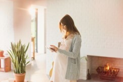 Sigue algunos consejos para enfrentar los cambios en los senos Mujer embarazada mirando un dispositivo