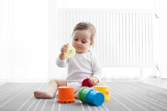 Incentivar a los bebés con los juguetes es una alternativa para motivarlos a sentarse solos Bebé sentado jugando con sus juguetes