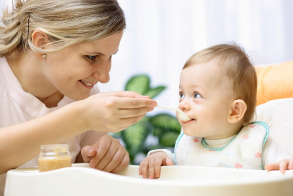 Un bebé de 6 meses siendo alimentado por su madre