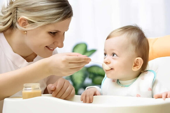 Una silla alta para alimentar mejor a tu bebé Mamá alimentando a su bebé en su silla