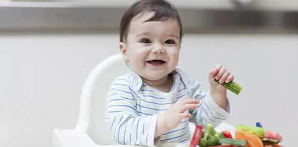 Bebé de 9 meses cogiendo alimentos sólidos