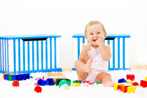Bebé de 9 meses sentada jugando en su lugar seguro