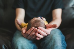 Papá alzando su bebé en sus piernas