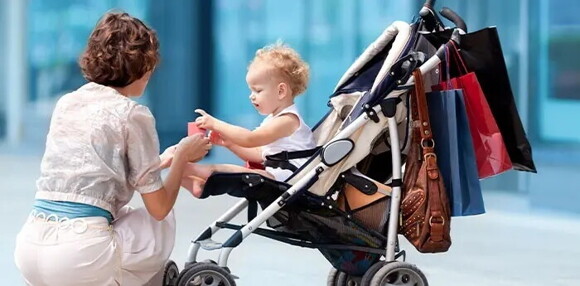 Revisa que los coches para bebés tengan compartimientos para llevar lo necesario. Mamá paseando con su hijo en un coche para bebés.