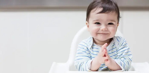 Conoce el desarrollo emocional de tu bebé de 10 meses. Bebé de 10 meses sentado sonriendo