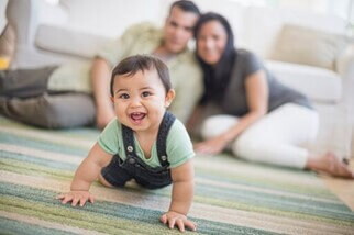 Bebé de 7 meses gateando en compañía de sus padres