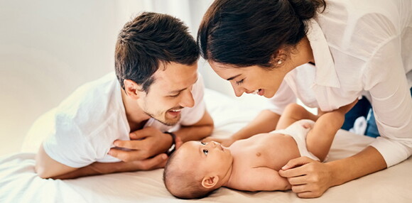 Cambios de temperatura y la contaminación son causas de la congestión nasal del bebé. Papá y mamá felices luego de descongestionar la nariz del bebé.