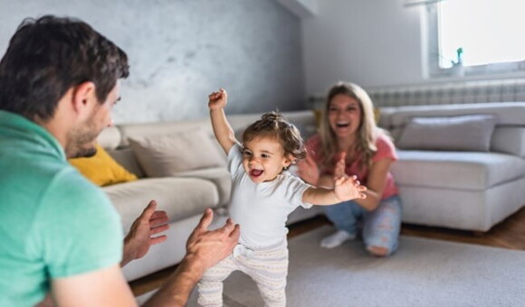 Conoce los síntomas de la displasia de cadera. Papá y mamá viendo cómo camina la hija.