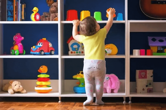 niño explorando estante de juguetes