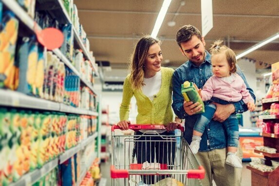 Papá y mamá en el mercado comprando probióticos saludables.