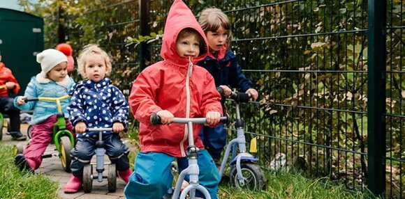 La motricidad gruesa contribuye al desarrollo de habilidades cognitivas. Niños montando triciclo.