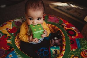 Bebé de 7 meses sentado jugando con sus juguetes