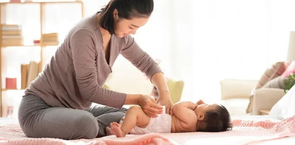 Mamá primeriza cambiando el pañal de su bebé.