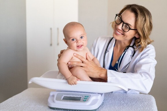 Doctora revisando el crecimiento y desarrollo del bebé.