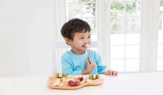 Niño contento consumiendo probióticos saludables.